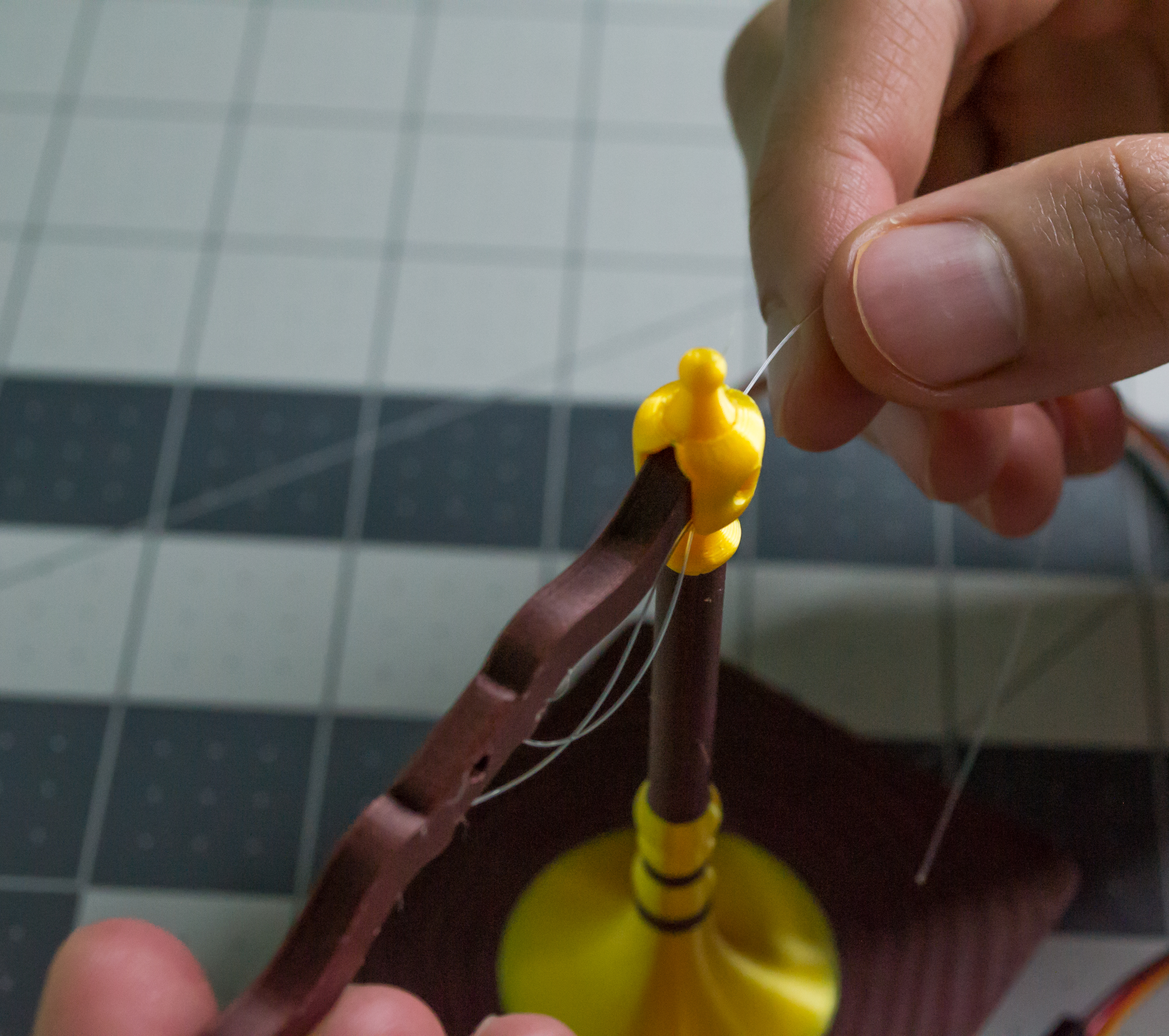 Taking one side of the monofilament and pushing the lever component through the tipping point on VintageScale.