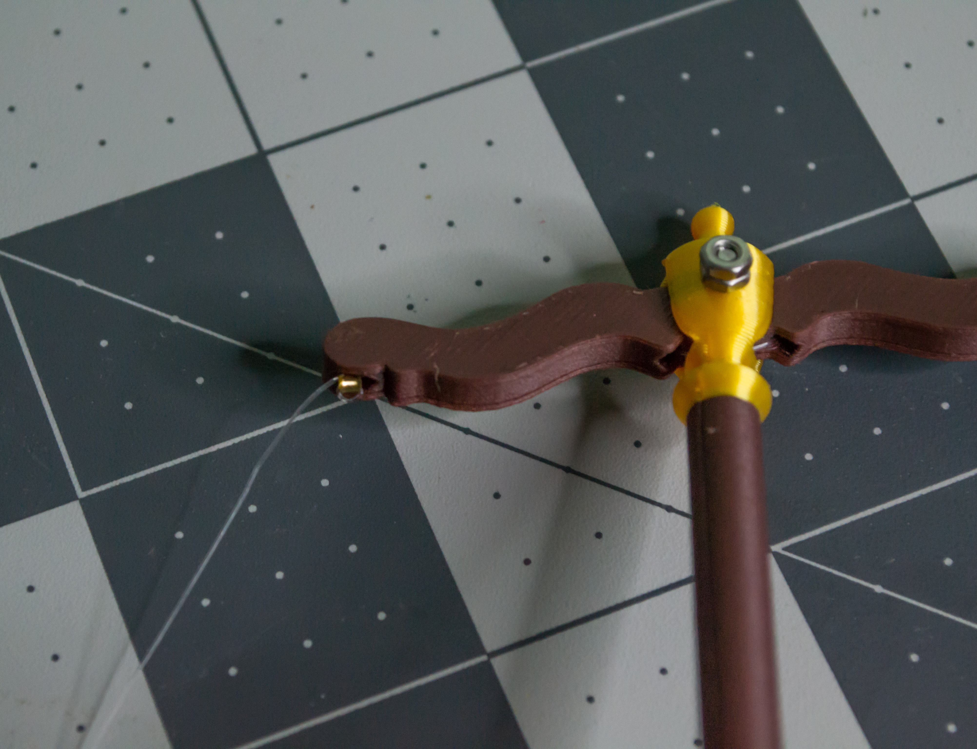 Moving the small gold crimp bead into place as close to the lever arm as possible on VintageScale.