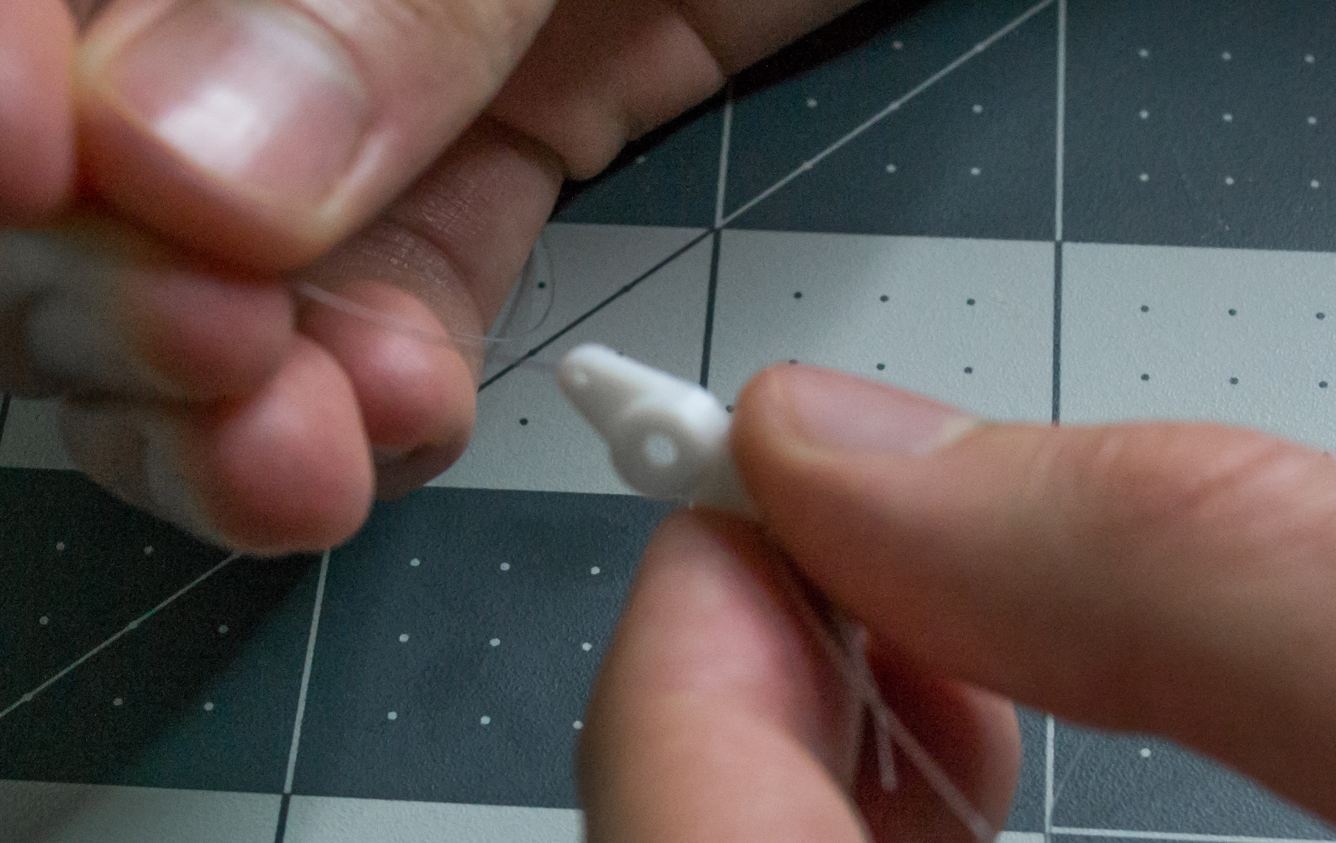 Putting monofilament through a small hole on the arm component for VintageScale.
