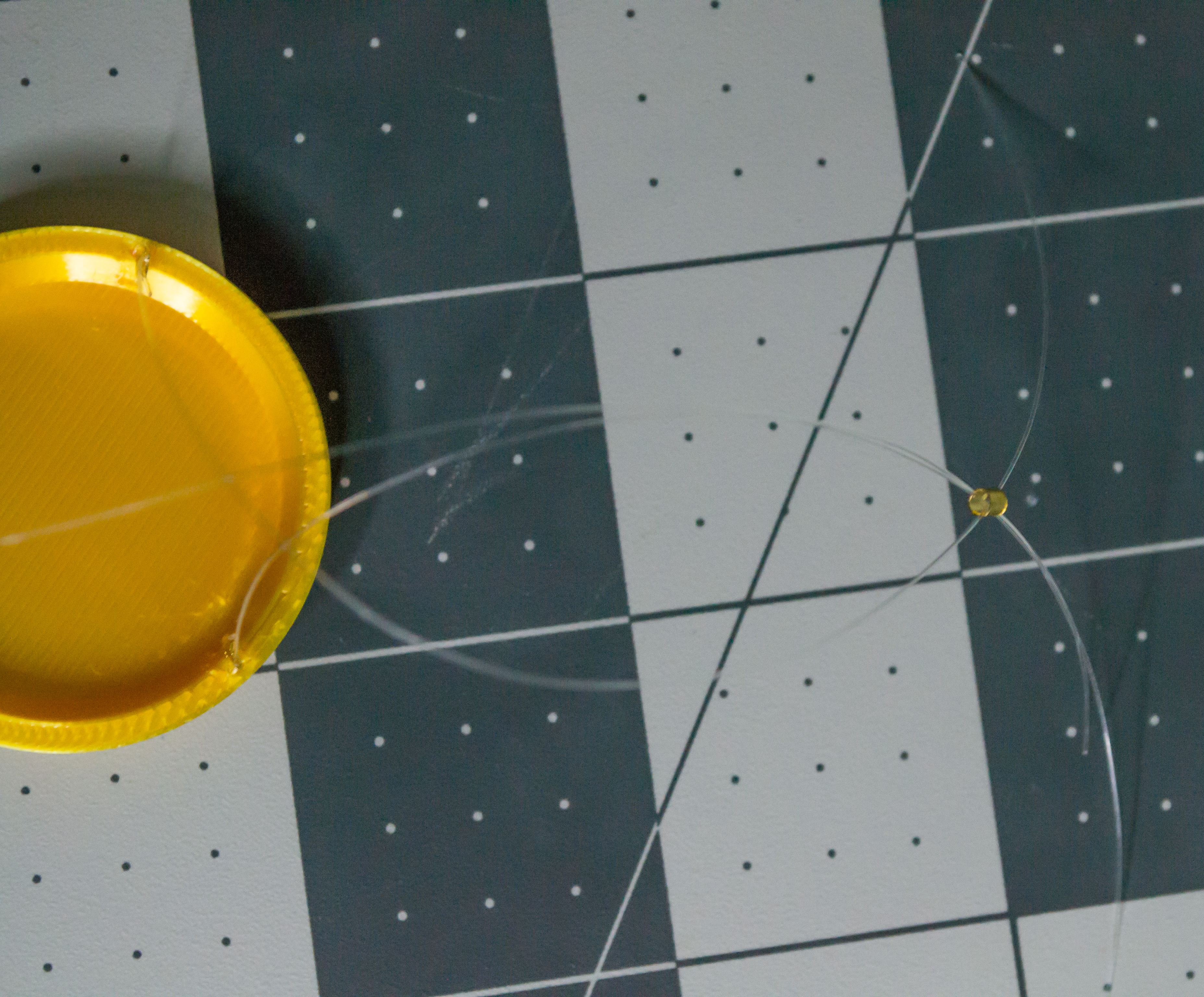 Placed medium gold crimp bead on three monofilament lines from a gold 3D printed plate for VintageScale.