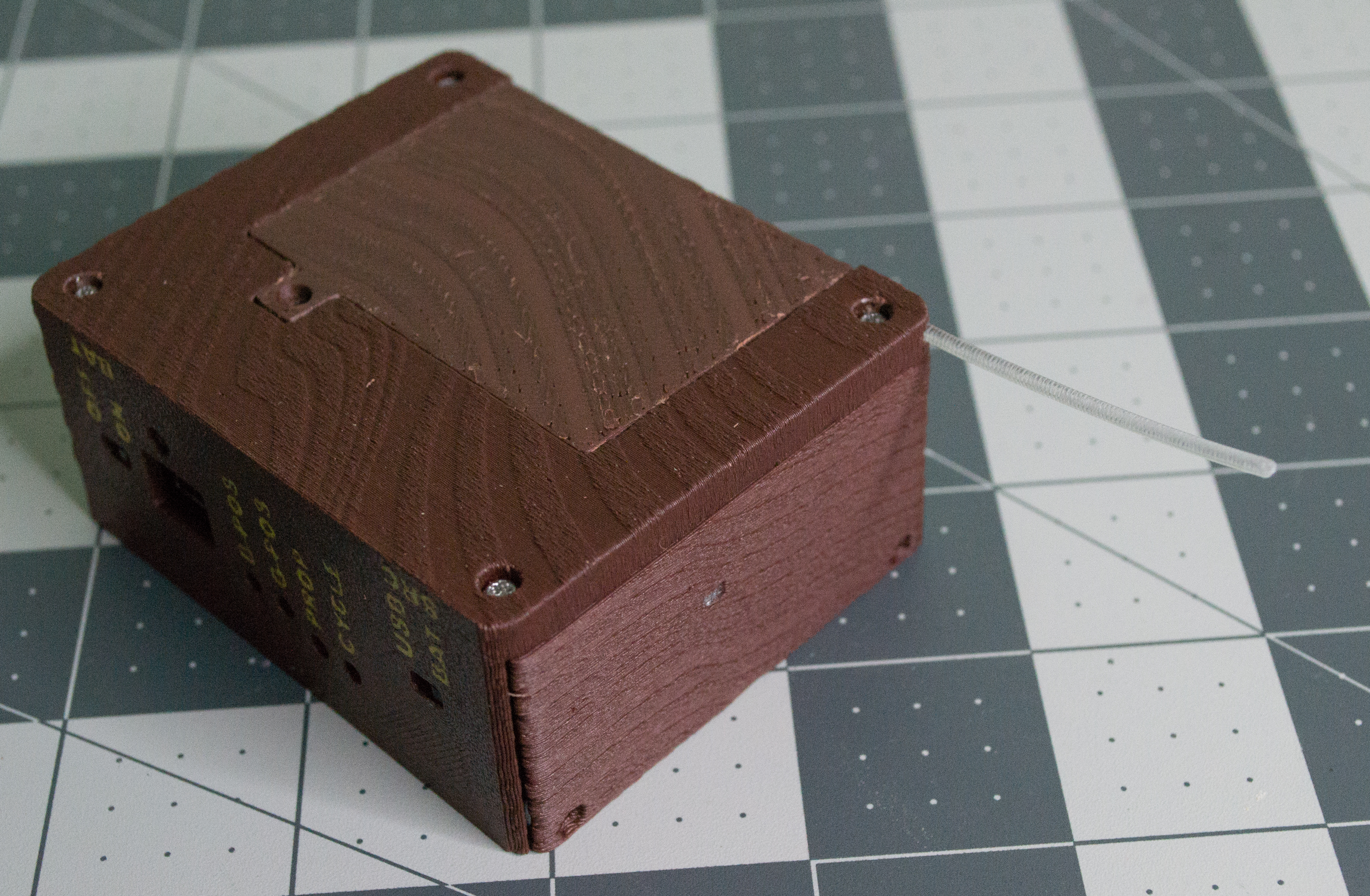 Inserting filament into the bottom and lid of VintageScale to create a filament hinge.