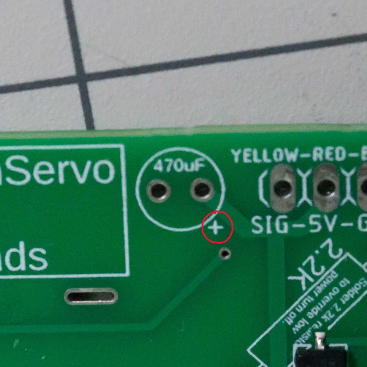 The plus sign circled on the TwoPositionServo controller board for the 470 uF capacitor.