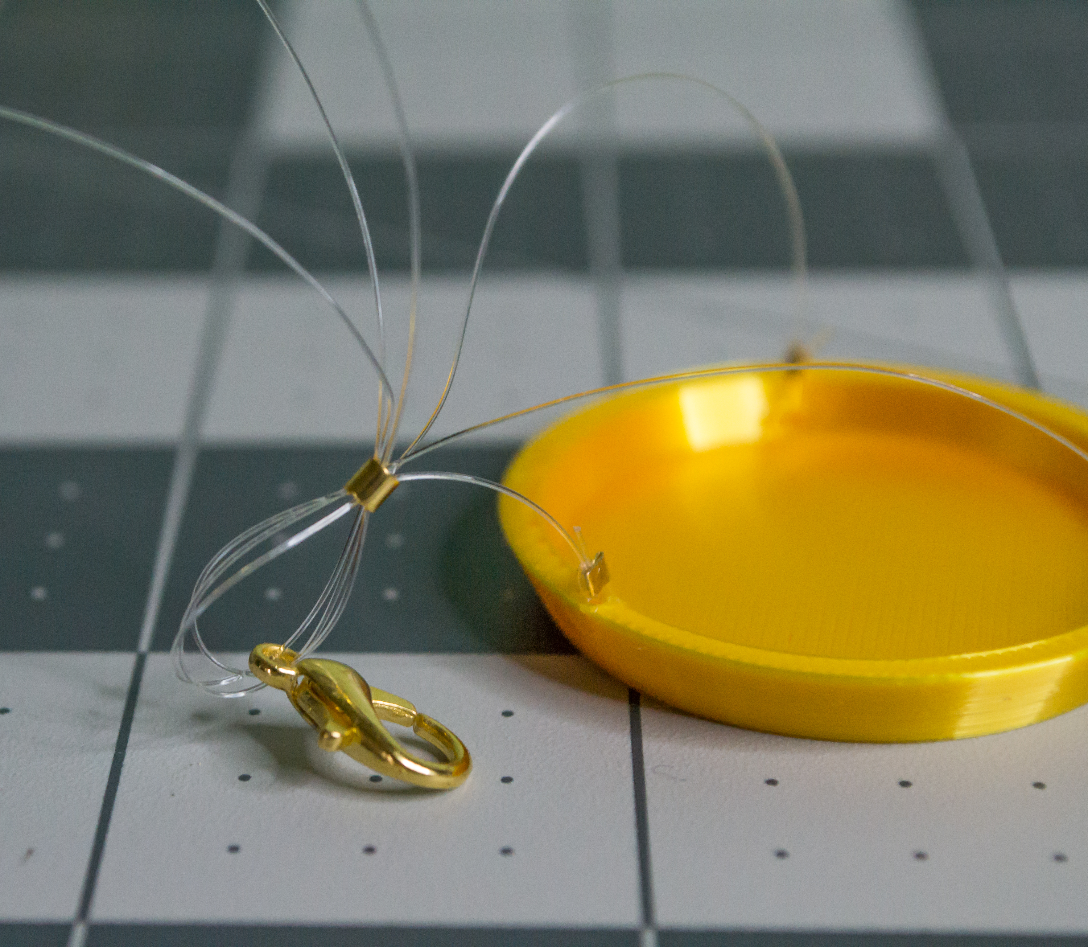 Looped three monofilament lines back from the lobster claw into the medium gold crimp bead on the VintageScale plate.