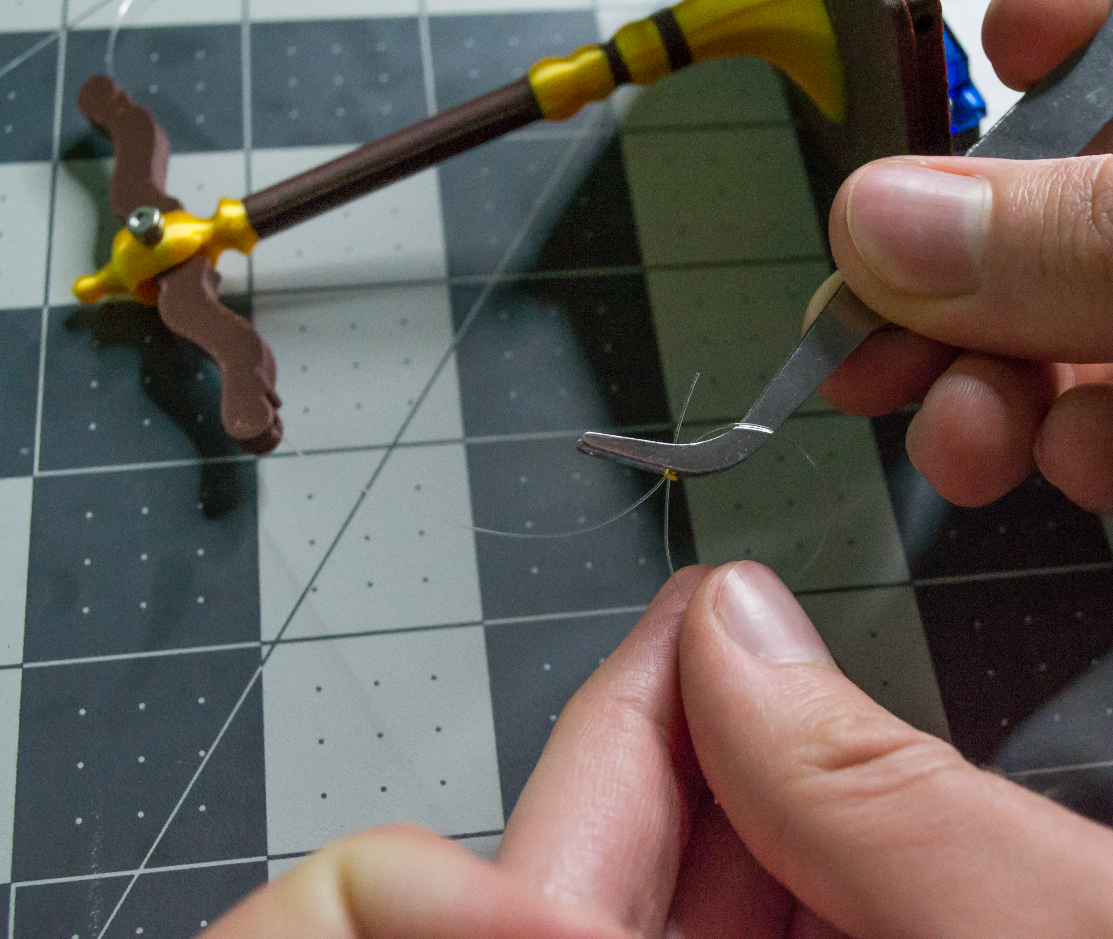 Creating a loop around the small gold crimp bead on the lever line for VintageScale.