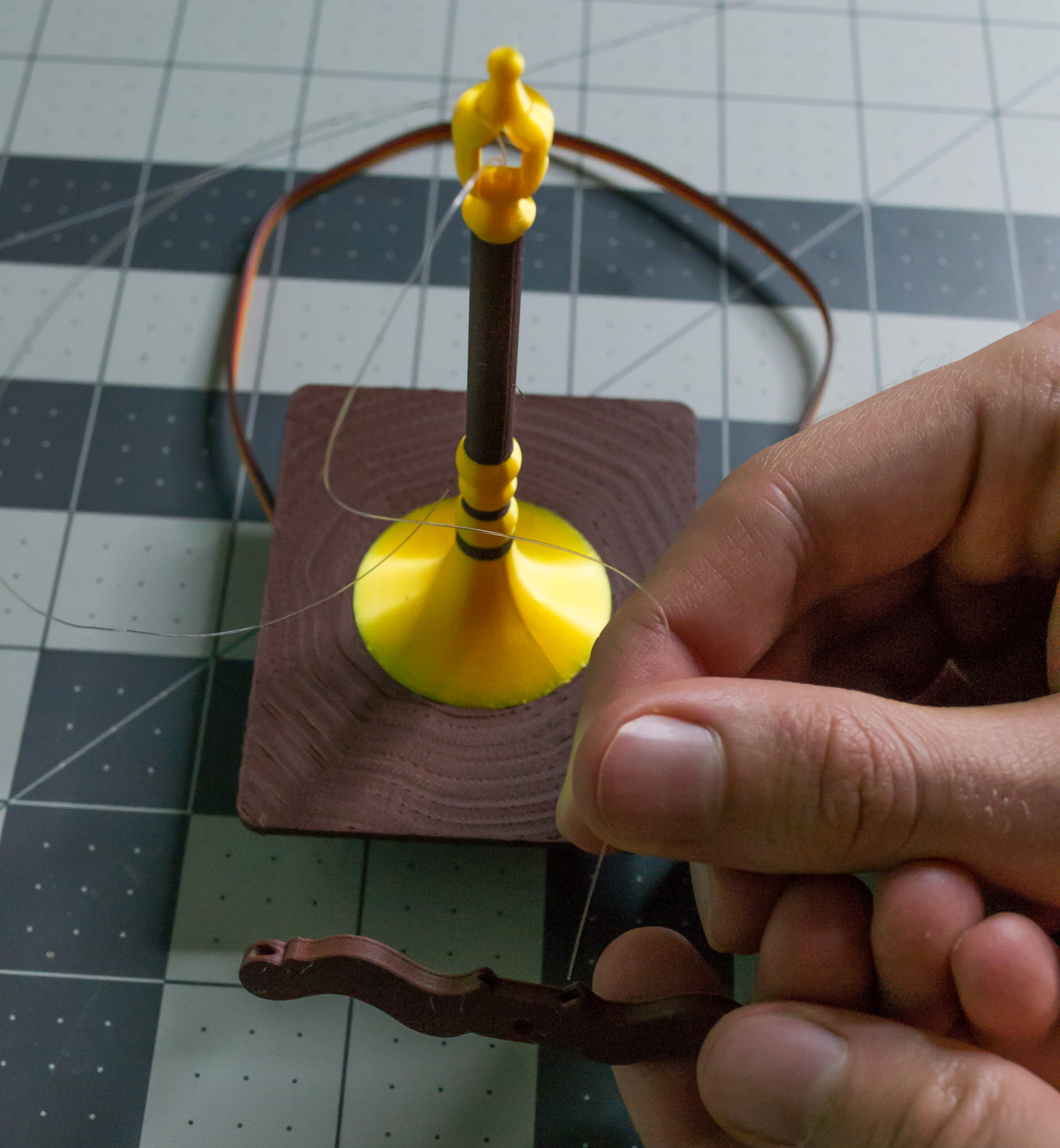 Inserting a monofilament line into the lever component on VintageScale.